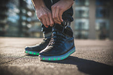 将图片加载到图库查看器，Man doing up his LED high top running shoes
